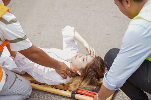 Closeup ambulance and rescue workers helping woman driver from car accident on road