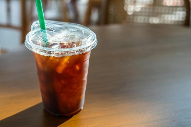 Closeup of Americano ice coffee or black coffee in cup mug on wood desk office desk in coffee shop at the cafe in gardenduring business work concept