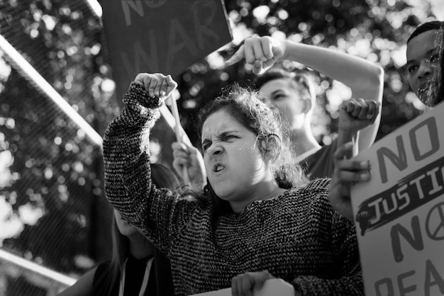 Photo closeup of angry teen girl protesting demonstration holding posters antiwar justice peace concept