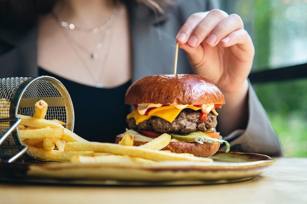 カフェでのクローズアップの食欲をそそるハンバーガーとフライドポテト