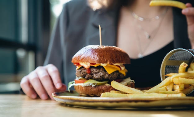 カフェでのクローズアップの食欲をそそるハンバーガーとフライドポテト