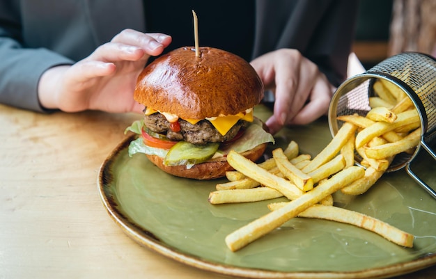 カフェでのクローズアップの食欲をそそるハンバーガーとフライドポテト