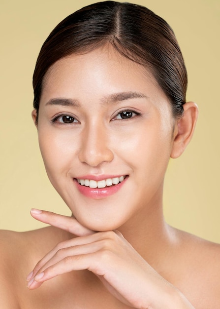 Closeup ardent young woman with healthy clear skin and soft makeup looking at camera and posing beauty gesture cosmetology skincare and beauty concept