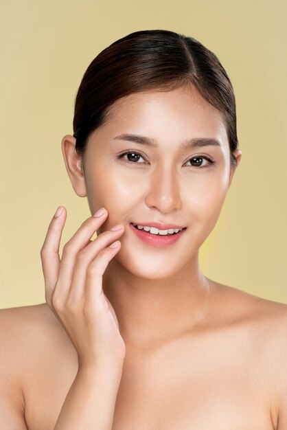 Closeup ardent young woman with healthy clear skin and soft makeup looking at camera and posing beauty gesture Cosmetology skincare and beauty concept
