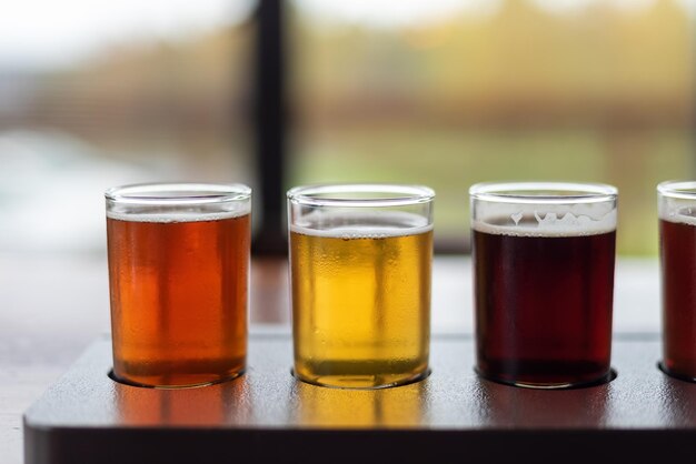 Foto close-up di un volo di birra artigianale in una varietà di stili su un tavolo di un ristorante