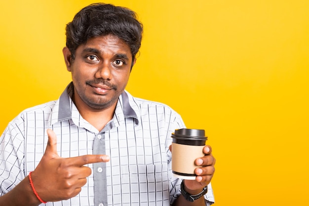 Closeup Asian happy portrait young black man smile holding coffee cup take away and pointing hand finger to coffee cup, studio isolated on yellow background