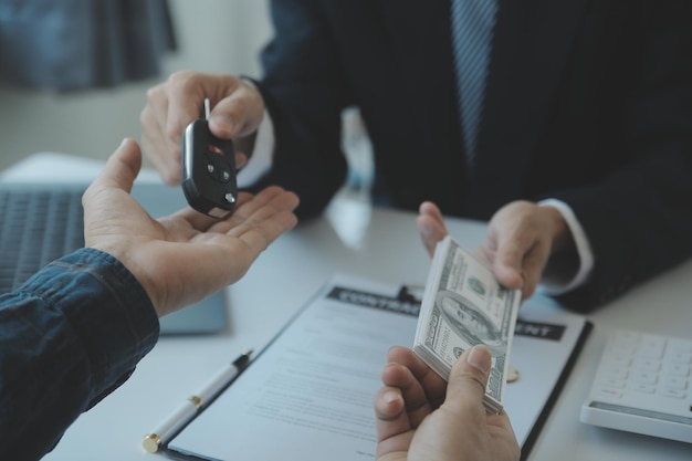 Closeup asian male people car salesman or sales manager offers to sell a car and explains and reads the terms of signing a car contract and insurance