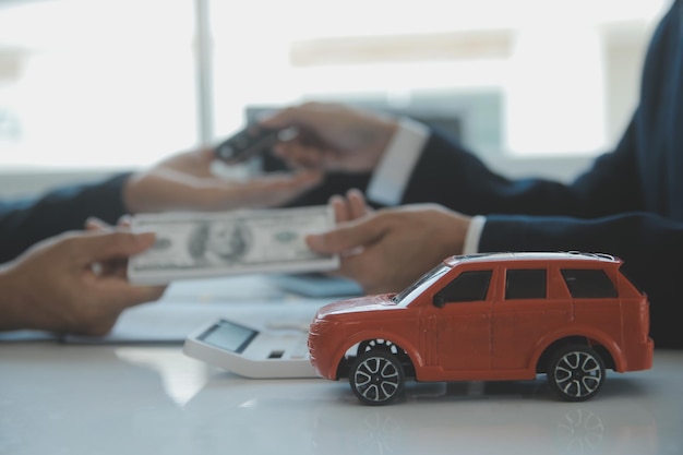 Closeup asian male people car salesman or sales manager offers to sell a car and explains and reads the terms of signing a car contract and insurance