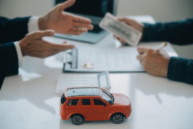 Closeup asian male people car salesman or sales manager offers to sell a car and explains and reads the terms of signing a car contract and insurance