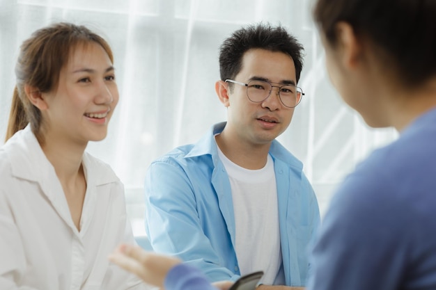 Closeup asian man talking to a group of people business men are\
meeting with a group of business partners to open a startup company\
a group of young energetic people to manage the company