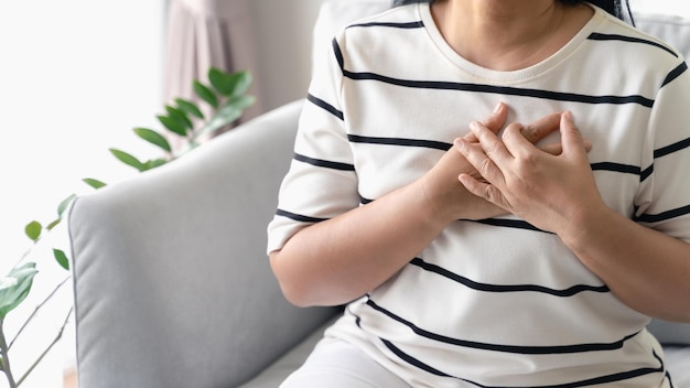 Closeup of Asian woman having heart attack Woman touching breast and having chest pain