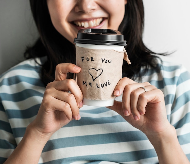 Closeup of Asian woman holding coffee cup