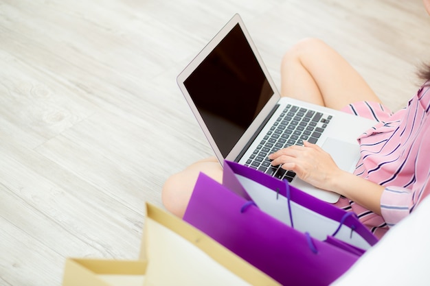 Closeup asian woman shopping online with laptop