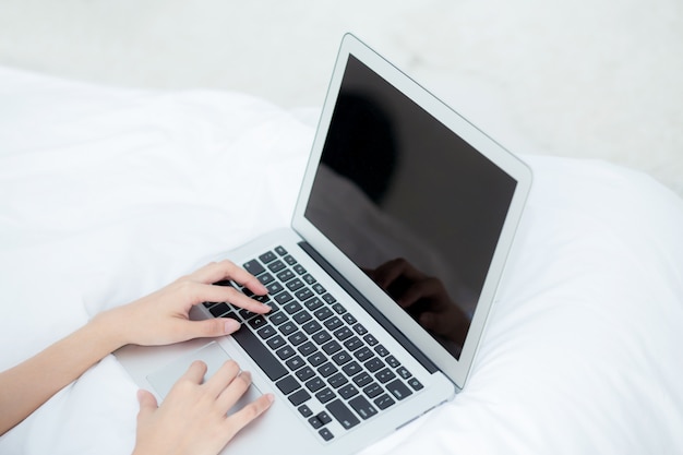 Closeup asian woman using laptop for leisure on bedroom