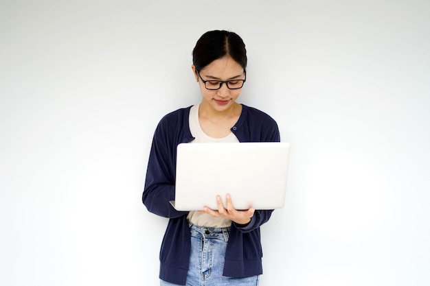 Closeup Asian young female student in casual cloth holding and action typing a laptop