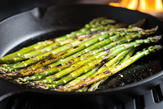 Closeup of asparagus tips lightly charred in a castiron skillet