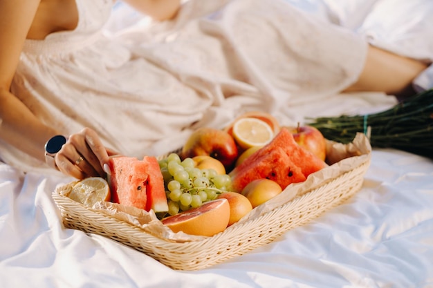 Closeup of assorted fruits on a tray The girl takes the fruit in her hands