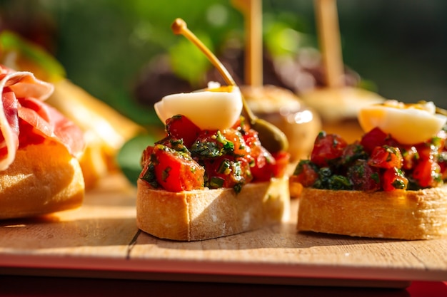 Closeup on assorted spanish tapas with different toppings on the wooden board