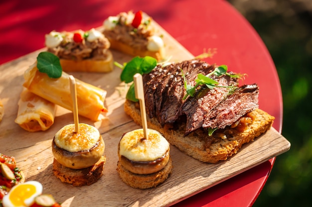 Closeup on assorted spanish tapas with different toppings on the wooden board