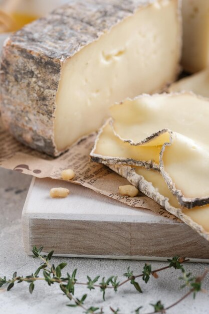 Closeup assortement of slices of soft cheeses on wooden board. Farm goat Cornish Yarg cheese