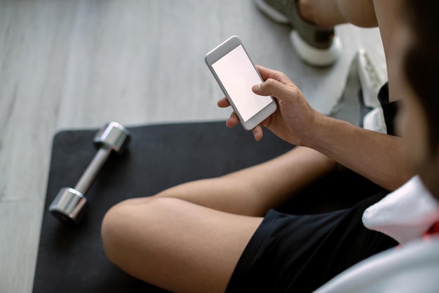 Closeup of athletic man using cell phone in a gym