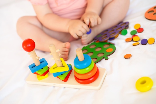 Closeup Baby is playing Infant learning and development Wooden ecofriendly educational toys Montessori system