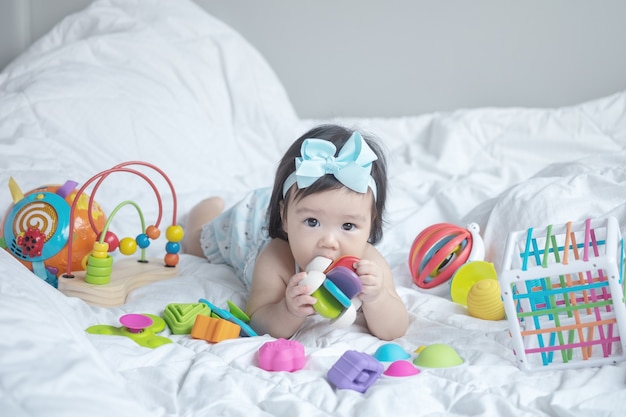 Closeup babymeisje liggend op bed met speelgoed