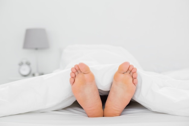 Closeup of bare feet in bed