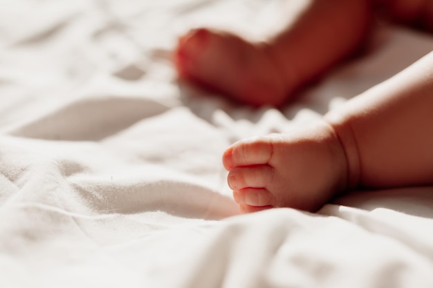 흰색 시트에 누워 있는 신생아의 맨발을 클로즈업 고품질 사진