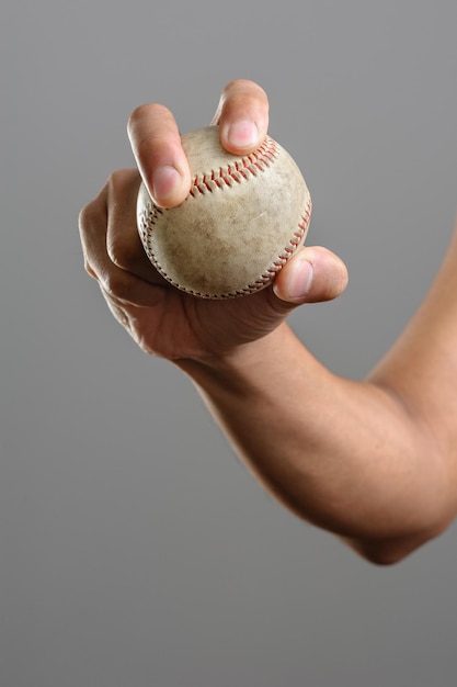 Closeup baseball in man's hand isolated over background