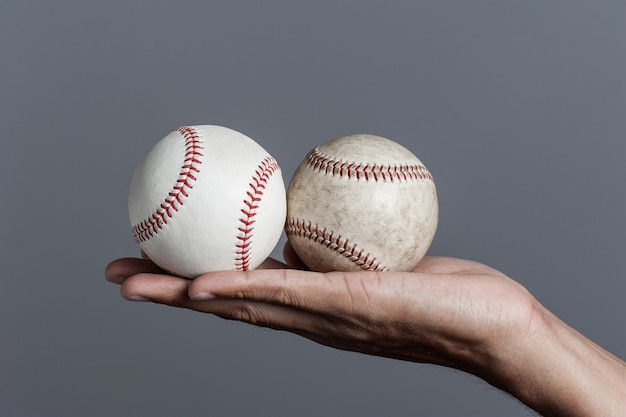 Бейсбол крупным планом в мужской руке изолирован на заднем плане