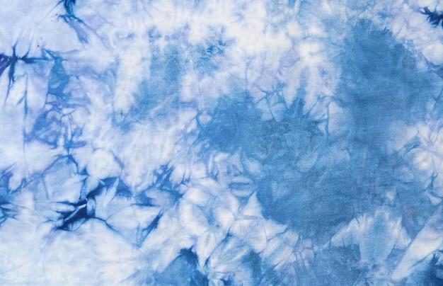 Closeup batik shirt with abstract indigo blue dye detail on white fabric cotton background