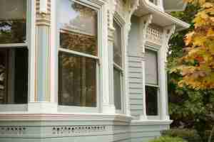 Photo closeup of bay windows detailed trimwork on victorian house