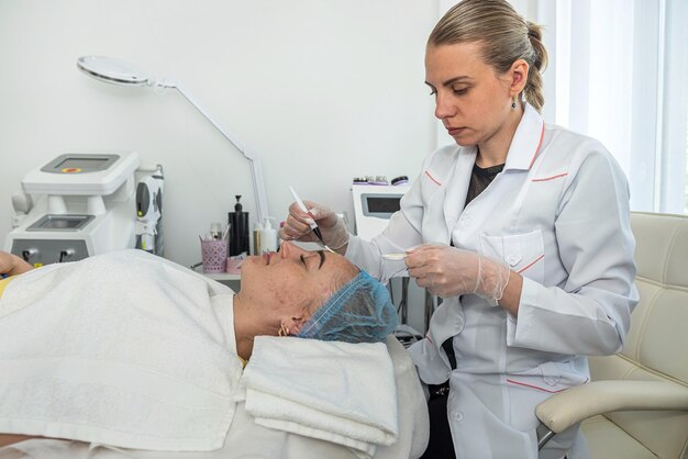 Closeup of a beautician doing rejuvenating procedures for a client's face in a spa or salon