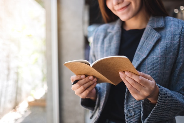 Closeup  of a beautiful asian businesswoman holding and looking at a notebook