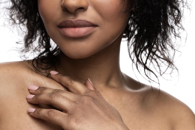 Closeup of beautiful black woman with a smooth skin is touching her clavicle