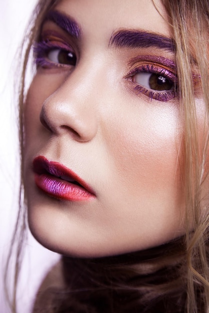 Closeup of beautiful fashion model with makeup and hairstyle on her face