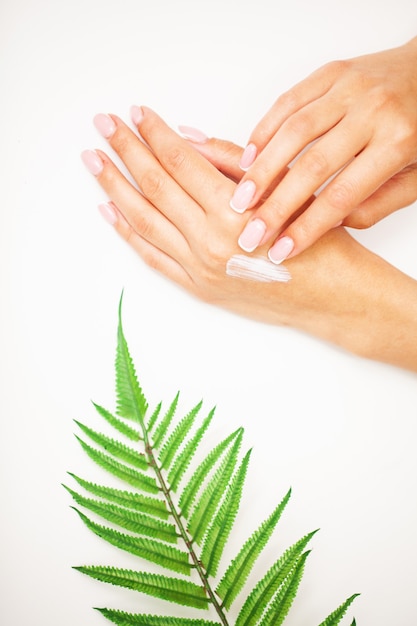 Closeup of beautiful female hand applying hand cream.