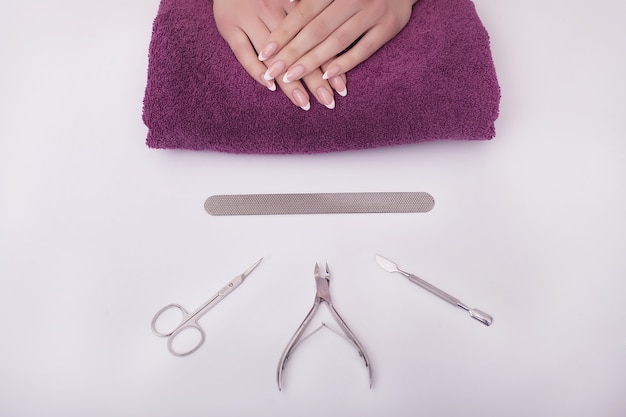 Closeup Of Beautiful Female Hands Applying Transparent Nail Polish On Healthy Natural Woman's Nails In Beauty Salon. 