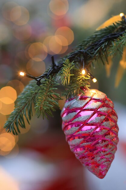 Foto closeup di bellissimi rami di abete con gioielli o palline decorazioni natalizie e giocattoli luci o ghirlande sfondo delle vacanze natalizie messa a fuoco selettiva