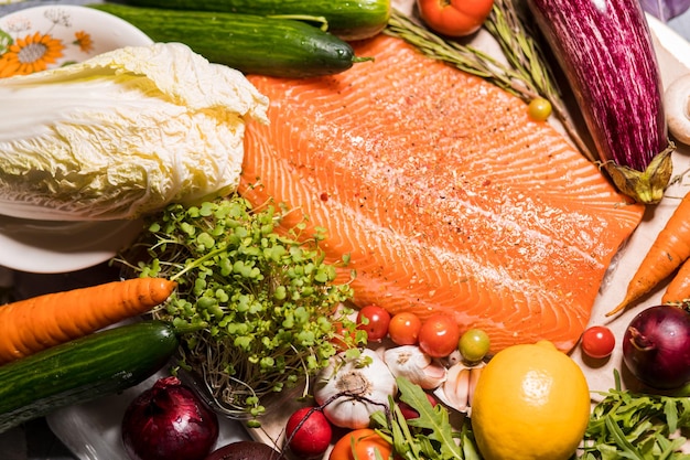 Closeup beautiful fresh salmon fillet with seasonings, herbs and vegetables on the table. Healthy food, restaurant, Haute cuisine, , diet concept. top view.