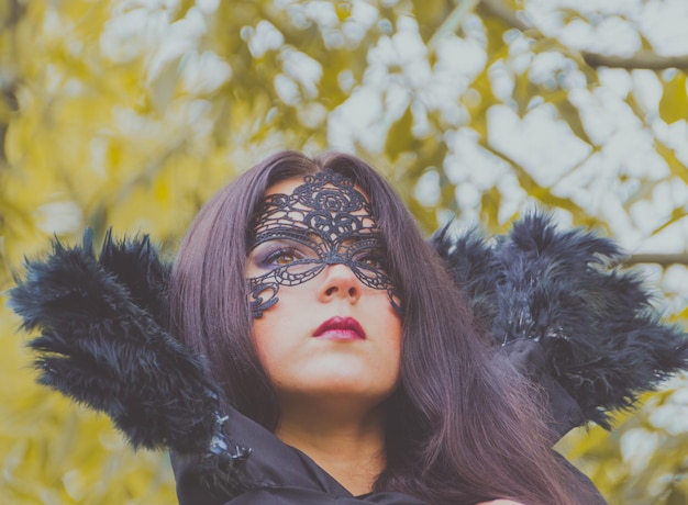 Closeup of a beautiful girl in a black mask and collar.