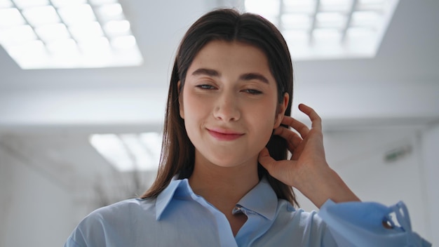 Closeup beautiful girl posing adjusting hair Young businesswoman in office