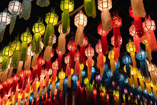 Photo closeup beautiful hanging colorful lanna style lighting paper lantern at night at festival in annual lantern hanging tradition in northern thailand at phra that hariphunchai temple, lamphun