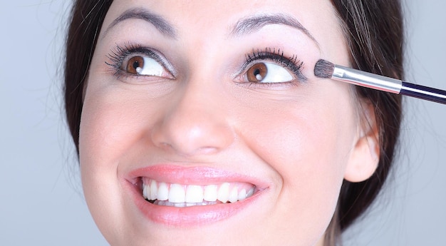 Closeup beautiful woman with brush for makeup