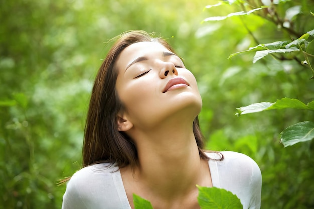 Closeup of beautiful woman with closed eyes on nature background