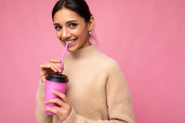 Primo piano di bella giovane donna bruna positiva che indossa abiti casual alla moda