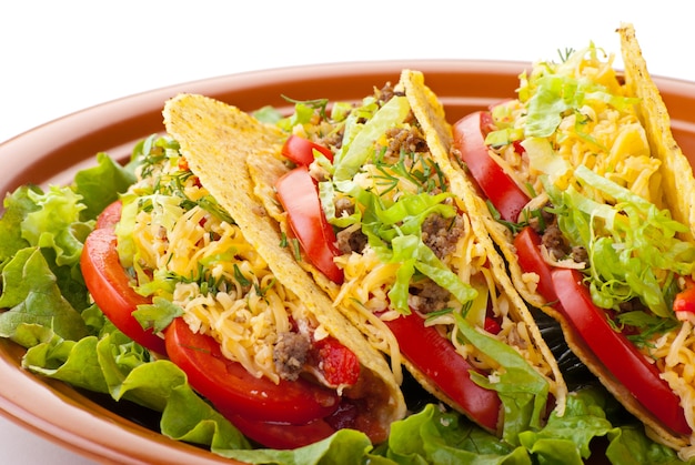 Closeup of beef tacos served with salad and fresh tomatoes salsa on white background