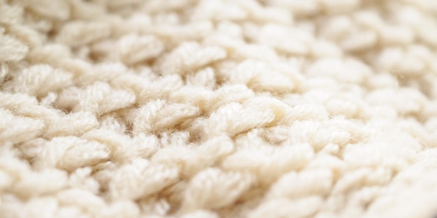 Closeup beige knitted woolen fabric texture background