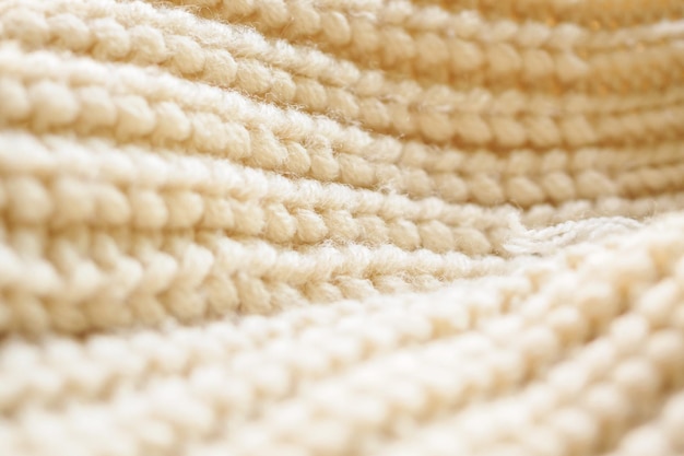 Closeup beige knitted woolen fabric texture background